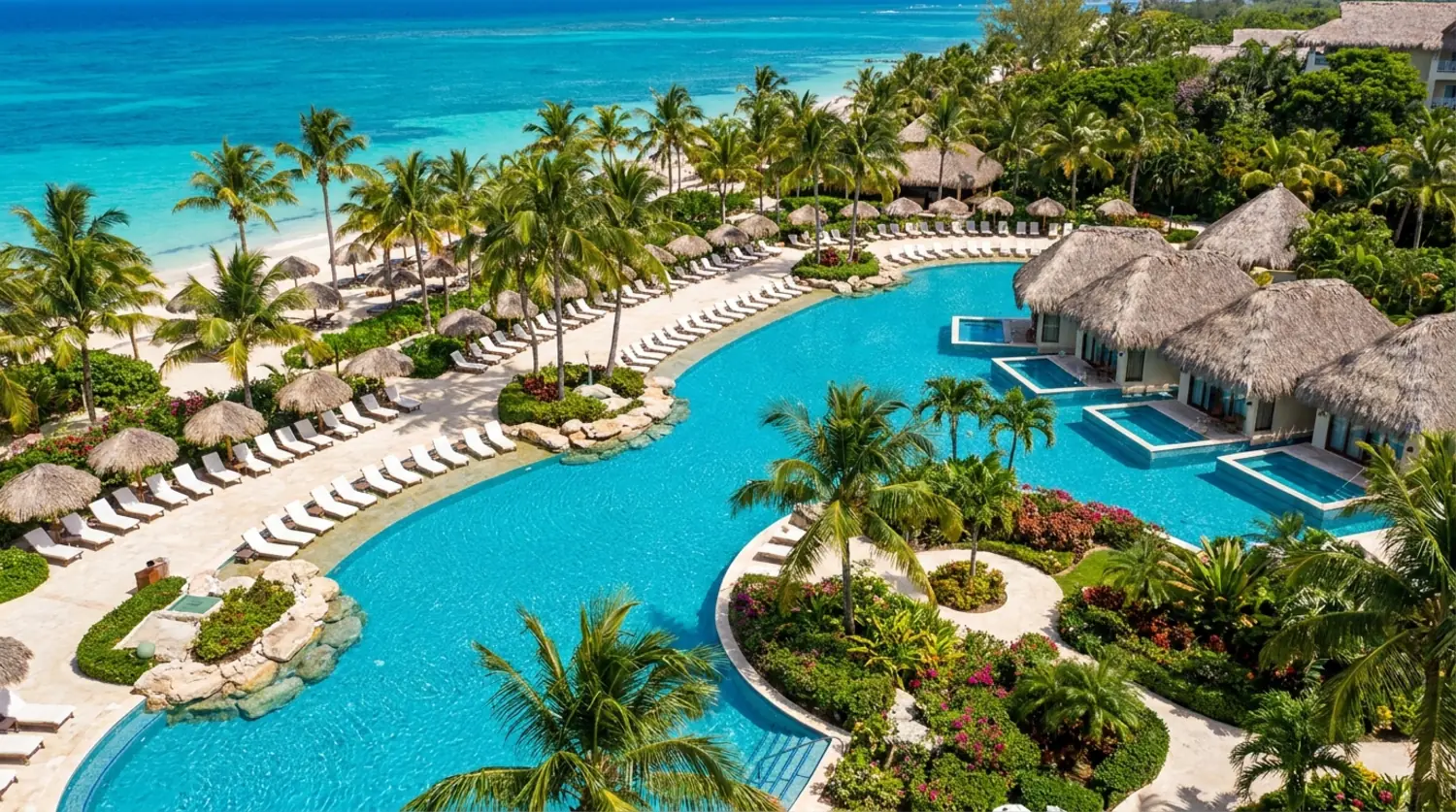 A Caribbean all-inclusive resort pool lined with palms and white loungers